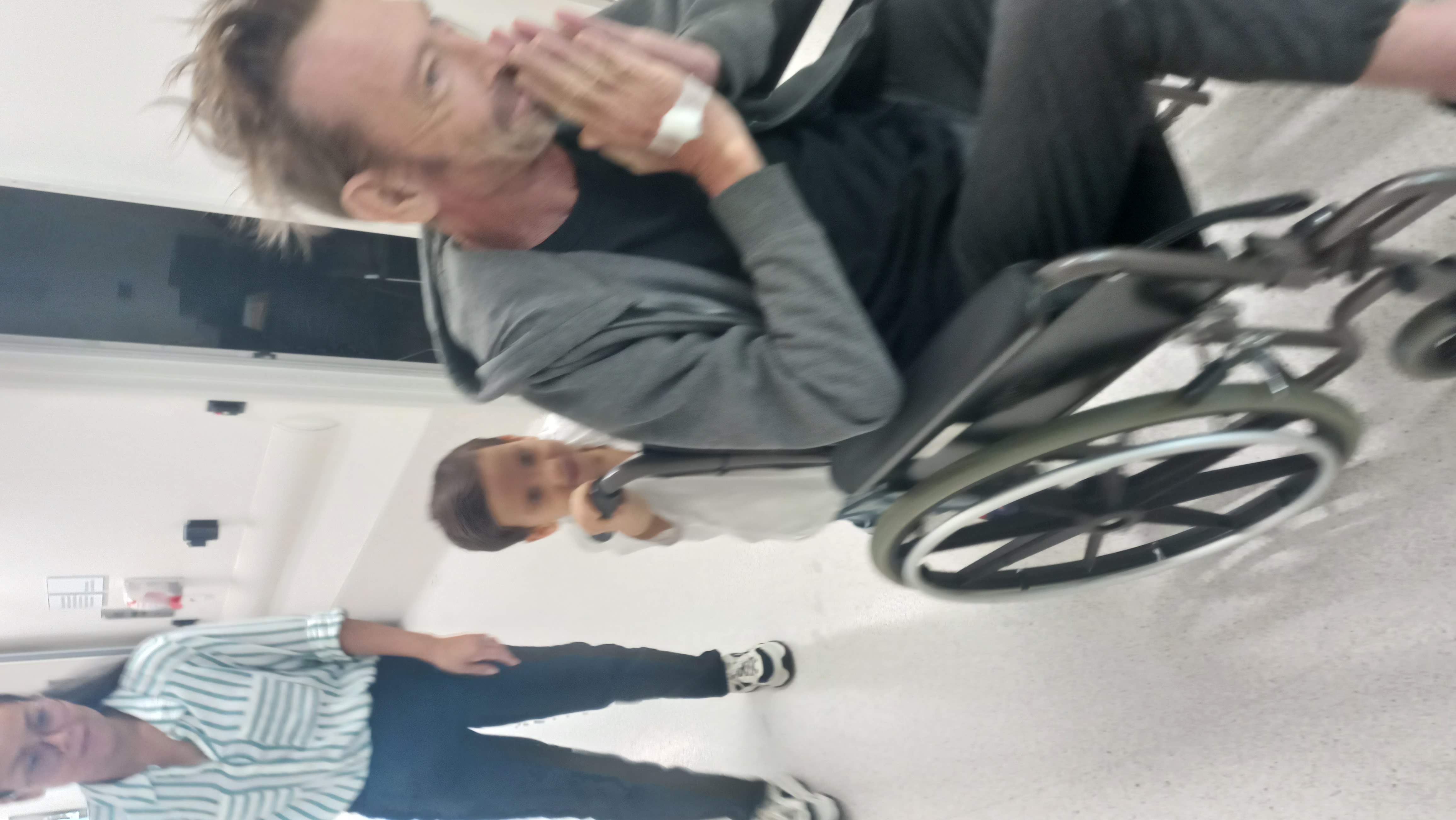 Oscar pushing Michael in wheelchair with Tar at Hospital in Perth