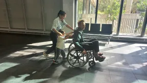 Oscar & Tar pushing Michael in wheelchair at Hospital in Perth