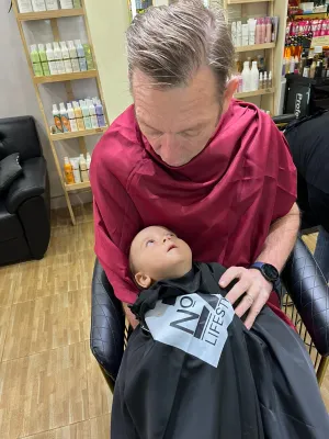 Michael holding Oscar getting haircut